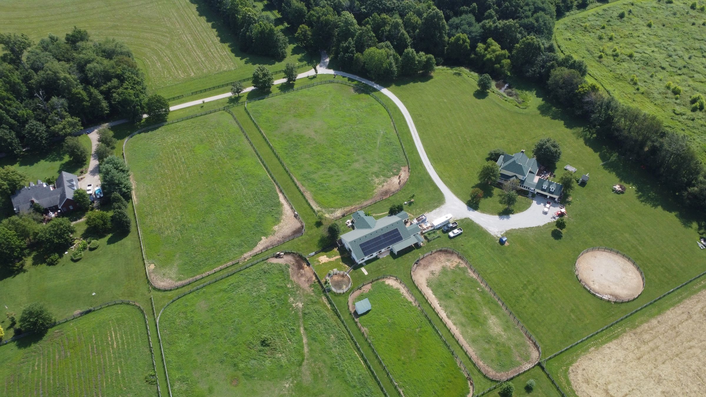 Aerial view of Blue Skies Horse Farm showing the barn, paddocks, round pen, and pastures